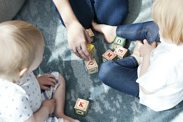 Toddlers playing with letter blocks