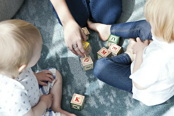 Toddlers playing with letter blocks