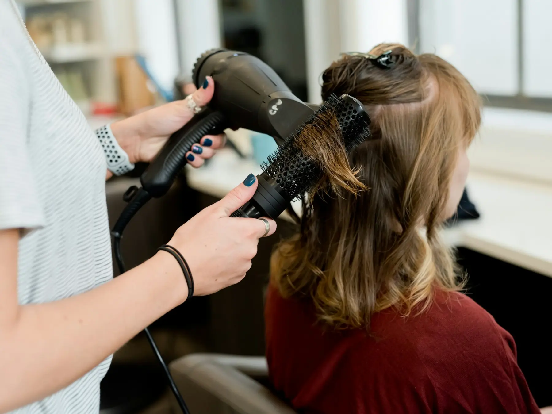 Stylist blow-drying a client's hair