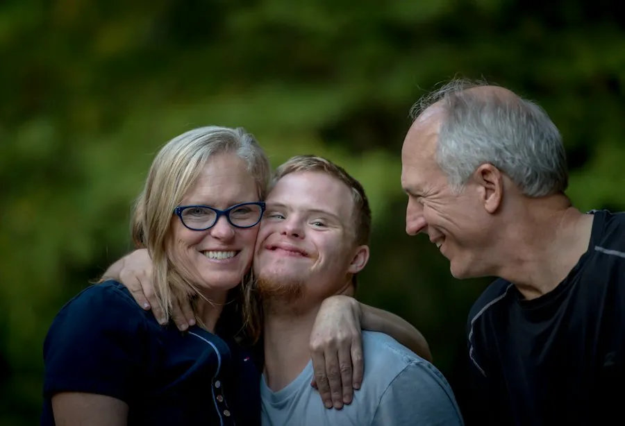 A family of three hugging and laughing together outside